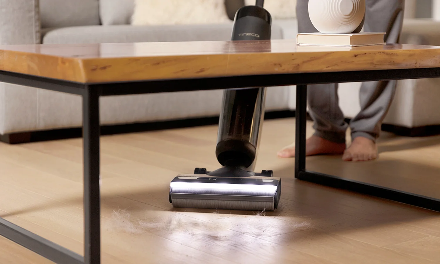Tineco cordless floor washer head operating under a low table