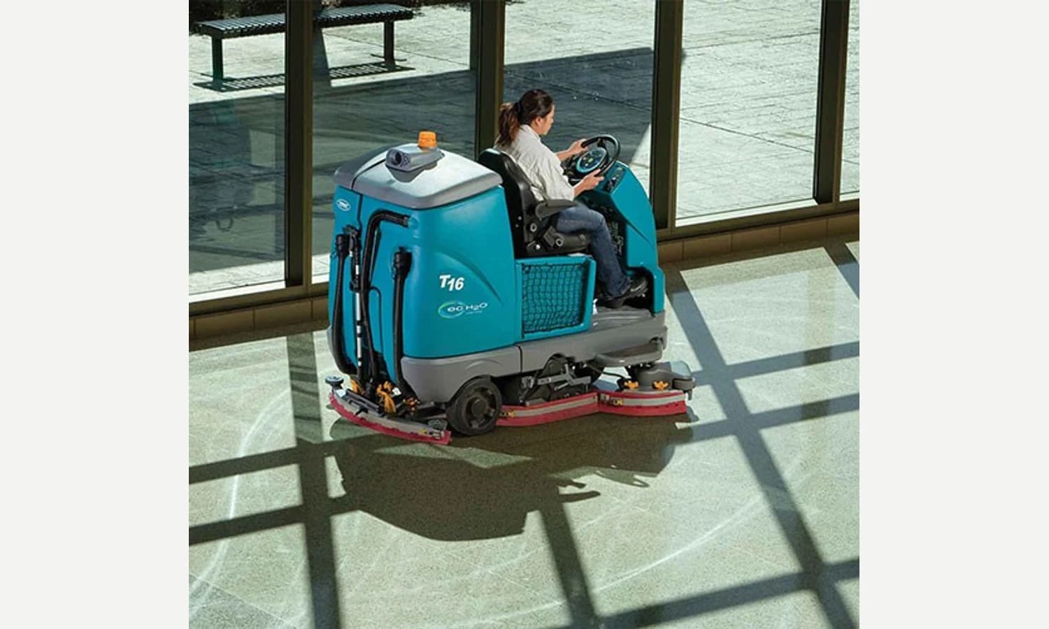 Tennant T16 ride-on scrubber cleaning an airport floor