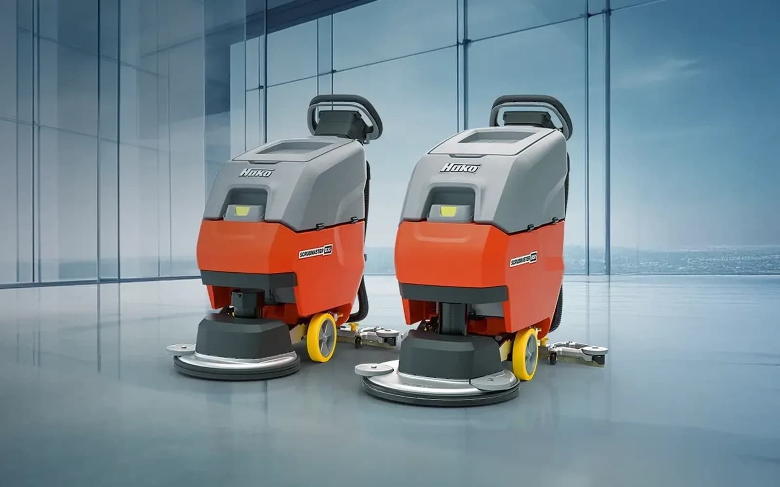 Two Hako Scrubmaster walk-behind floor scrubbers on a hard floor