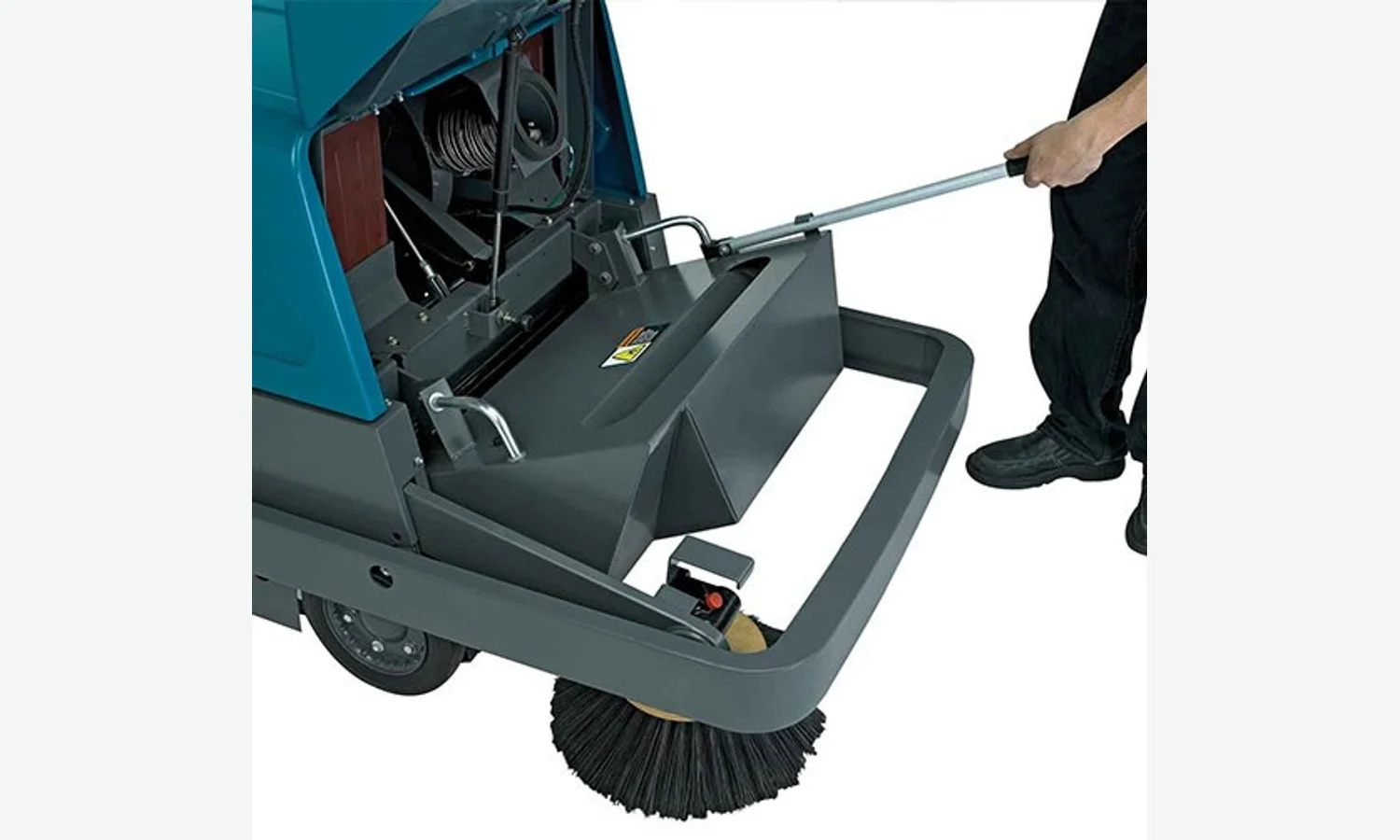 Operator emptying the hopper of a Tennant S10 walk-behind sweeper