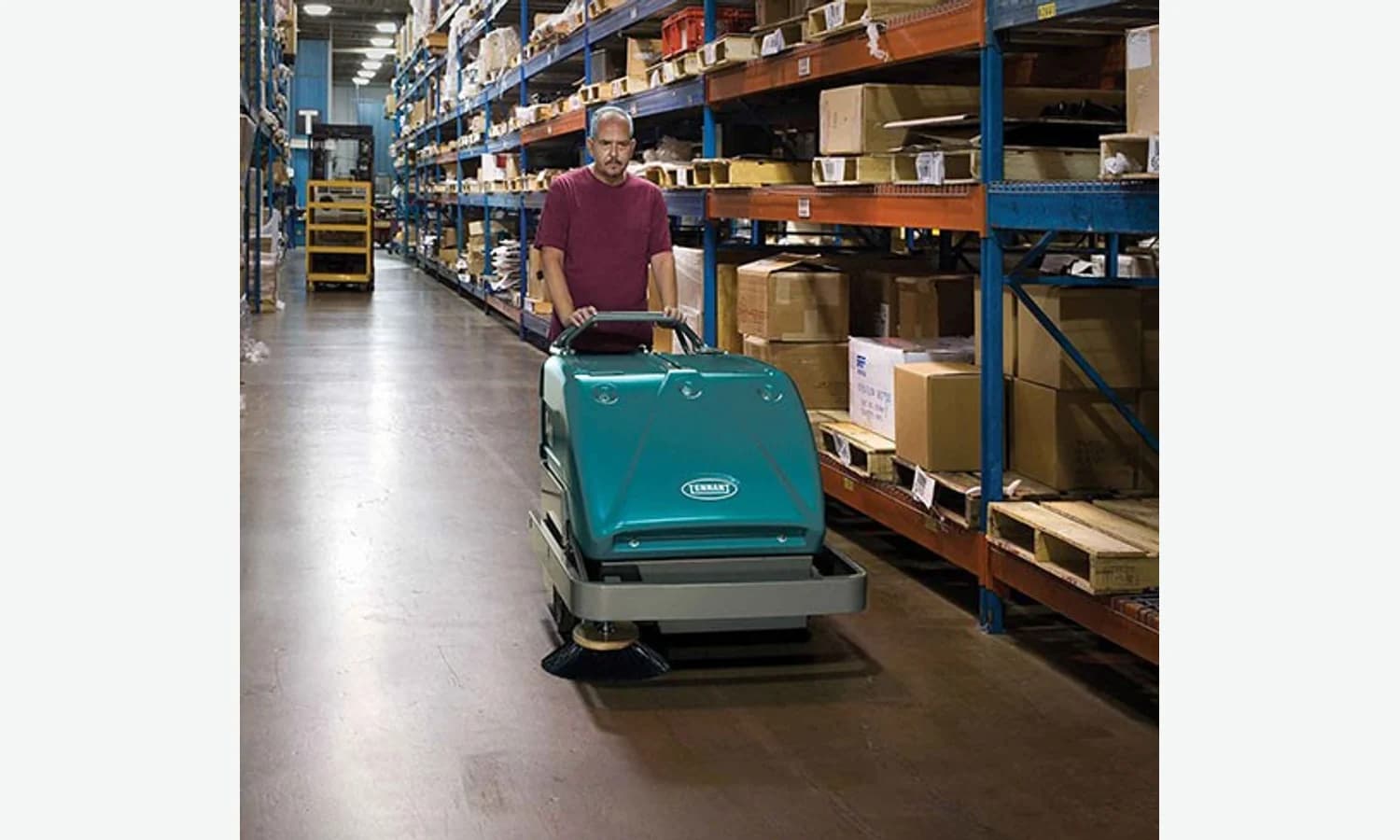 Tennant S10 walk-behind sweeper operating in a warehouse