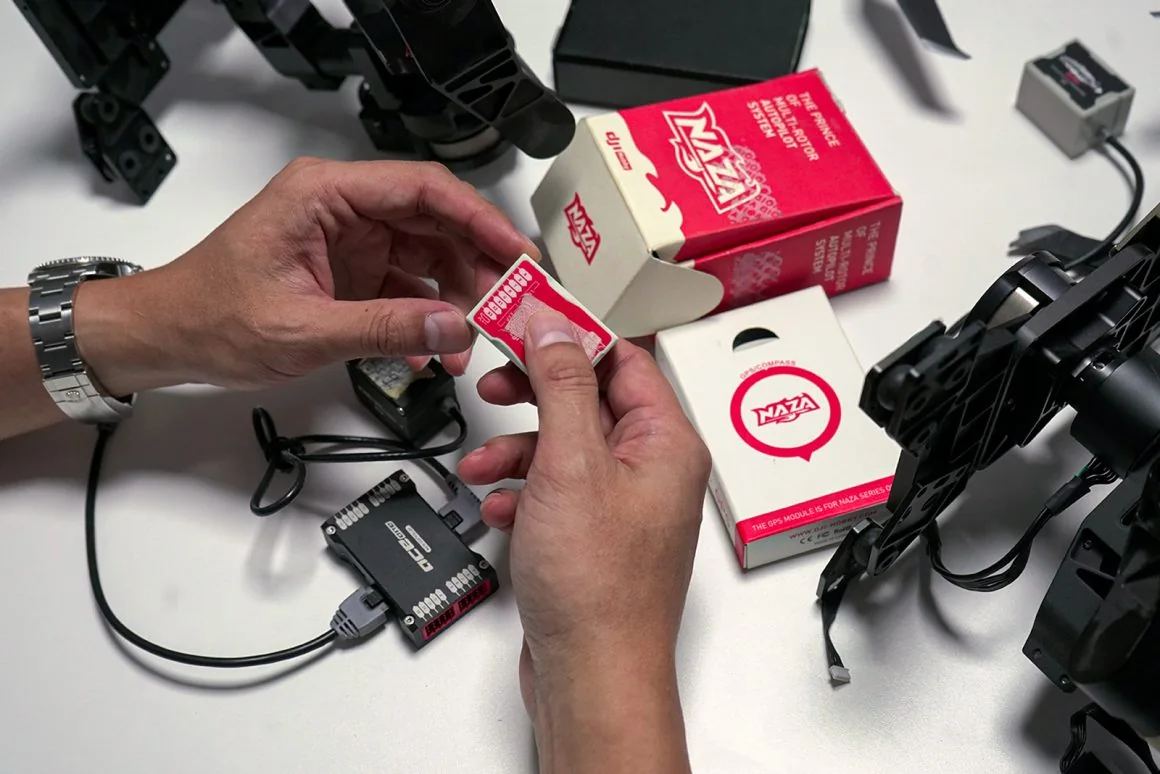 NAZA flight-control components and an aircraft frame on a workbench in DJI's retrospective.
