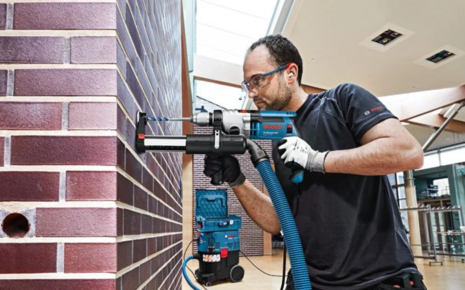 Bosch Professional drill and dust-extraction system used on a brick wall